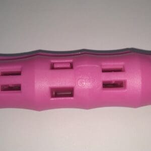 A pink plastic object is sitting on the floor.